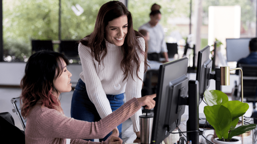 Two team members collaborating on Java code in an open office.