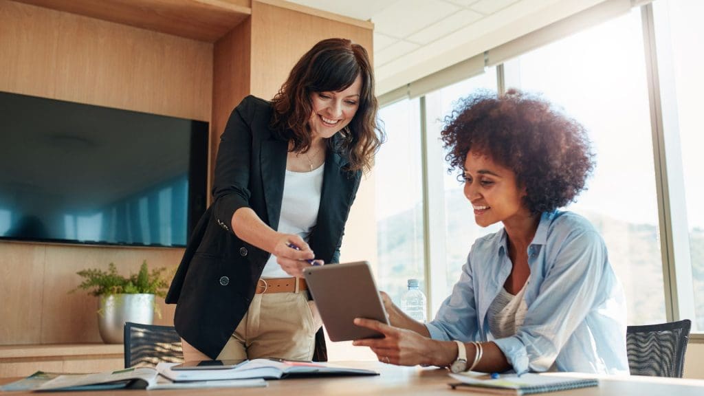 Two business professionals discussing digital transformation strategies on a tablet.